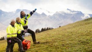 3-member search and rescue team on grassy mountain